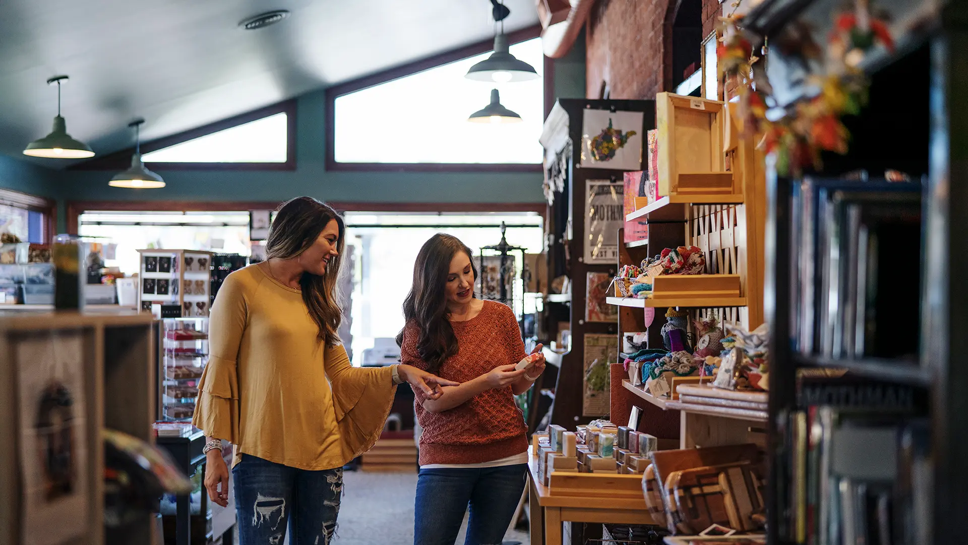 Two adults shopping and looking at handmade items inside a local gift shop